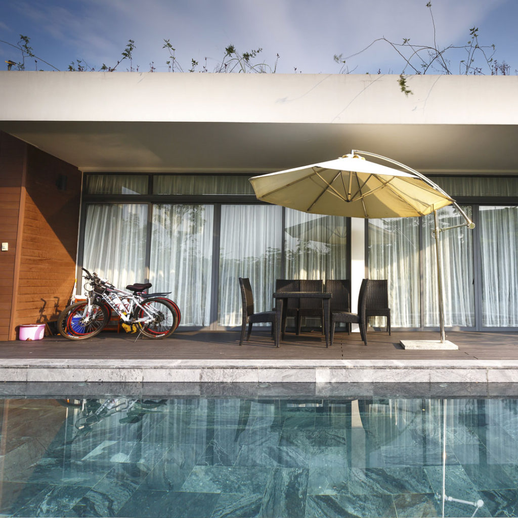 Piscina com mesa e bicicletas ao fundo